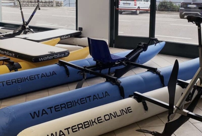Blue and white Waterbike Italia waterbikes on display in a showroom for the 10 December 2025 edition of Alphabetcity Magazine.